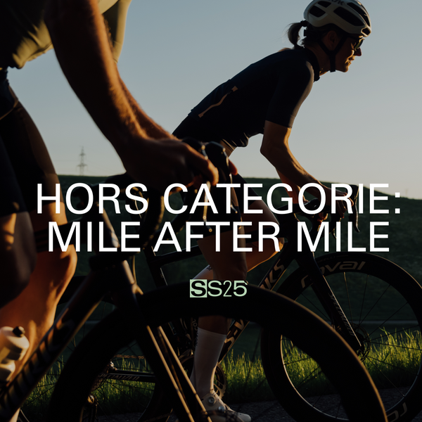 Close up of two cyclists going uphill in evening light, almost silhouetted. 