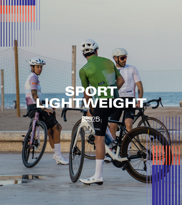 Five cyclists paused on a beachside road.