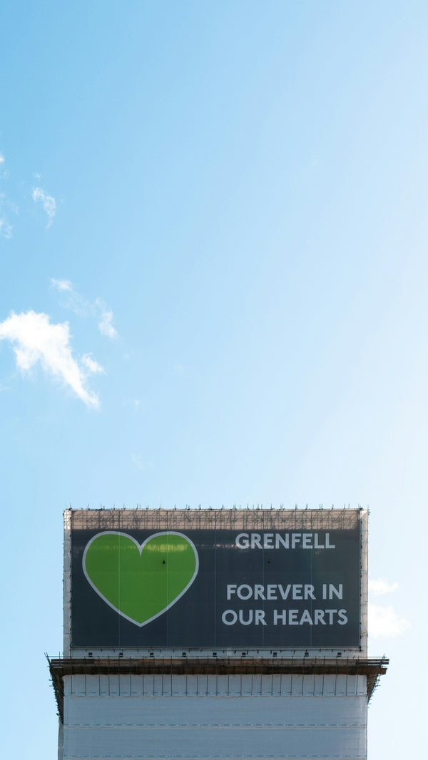 Grenfell tower with scaffolding around, blue sky backdrop