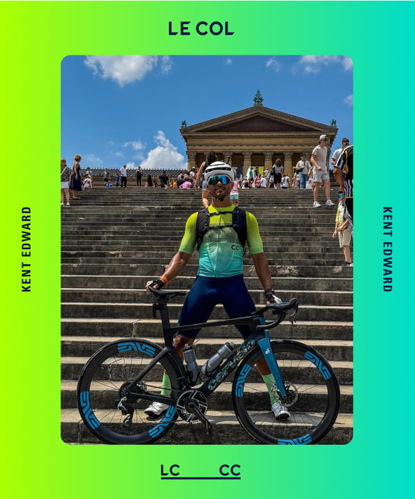 Cyclist with a bicycle on steps with a building in the background, wearing LCCC jersey