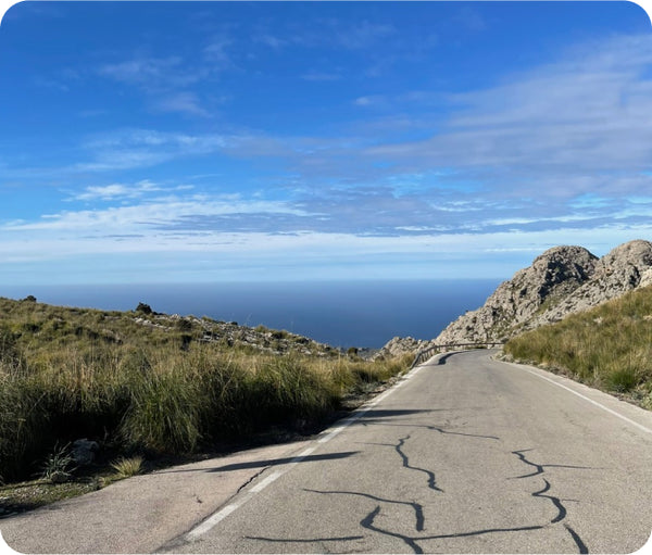 Coastal road with rocky outcrops and the sea behind