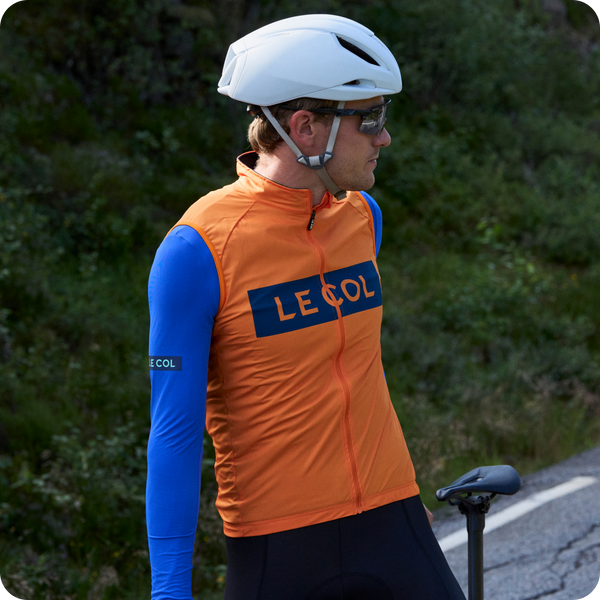 Male cyclist in saffron/navy sport logo gilet.