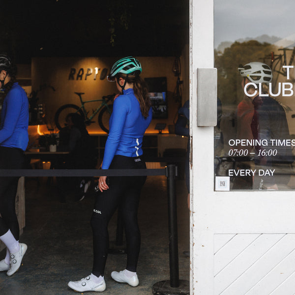 Female cyclists in line at a cafe.