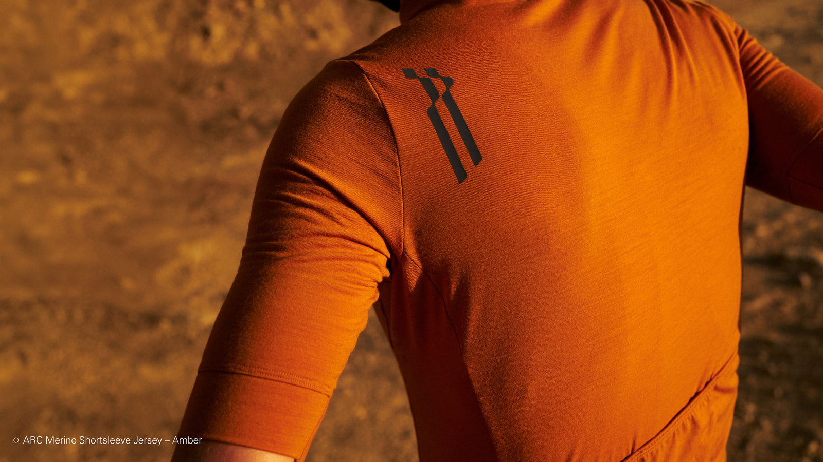 Back view of cyclist in Amber short sleeve jersey showing ARC logo on back of shoulder.