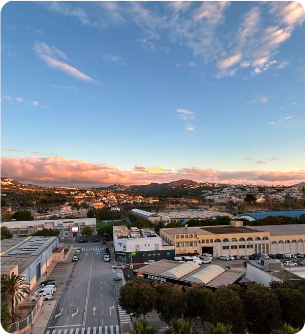 Looking down over a town amongst hills in evening light