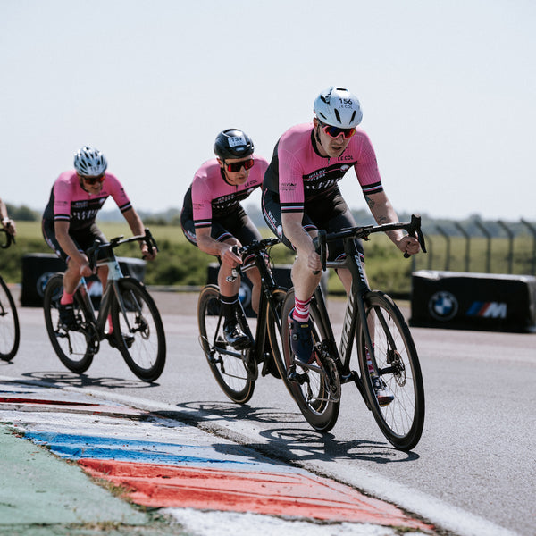 Three male 'wheelers' riding together in a race in their matching kit.