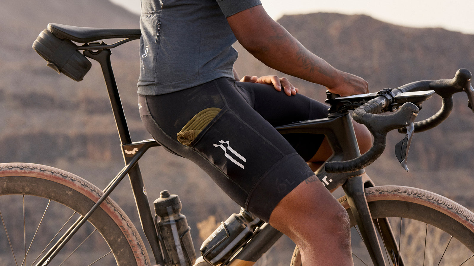 Male rider paused on bike showing side pockets of the bibshorts.