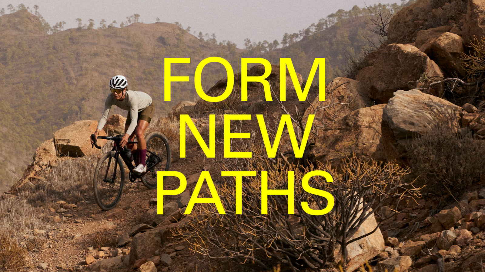 'Form new paths.' Female rider coming downhill through large boulders.