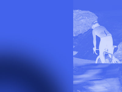 Person with a bicycle on a mountain road, blue filter applied