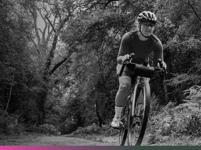 Person riding a bicycle on a trail in a forest