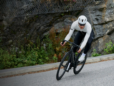 male and female cyclists riding towards the frame in blue and black jerseys