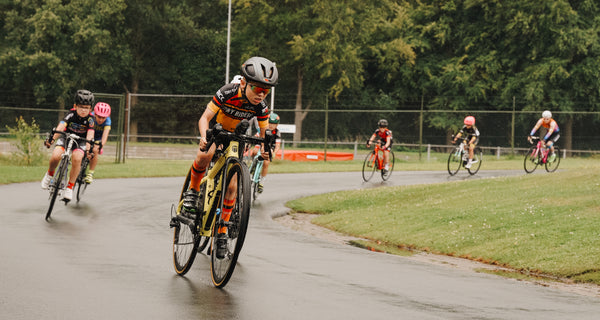The children mid race, coming round a bend in the rain. 