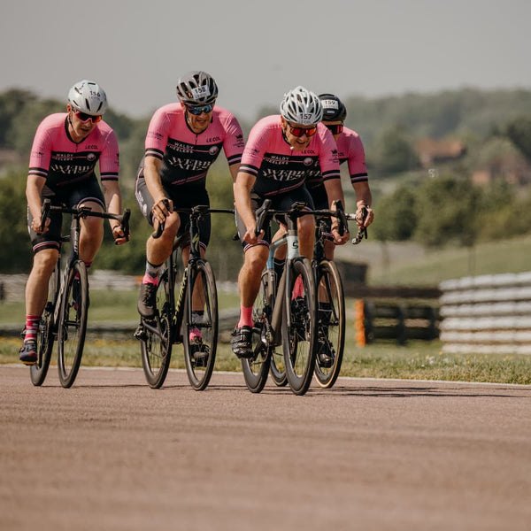 Four male 'wheelers' riding together in a race in their matching kit.