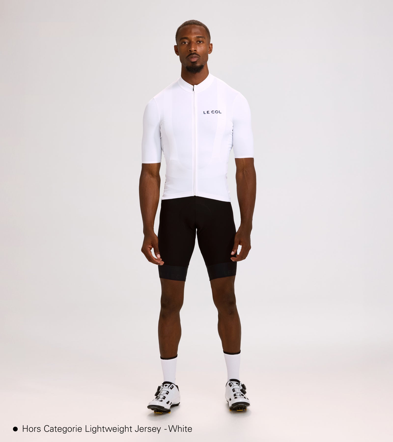 Studio shot of man wearing a white jersey and black bibshorts.