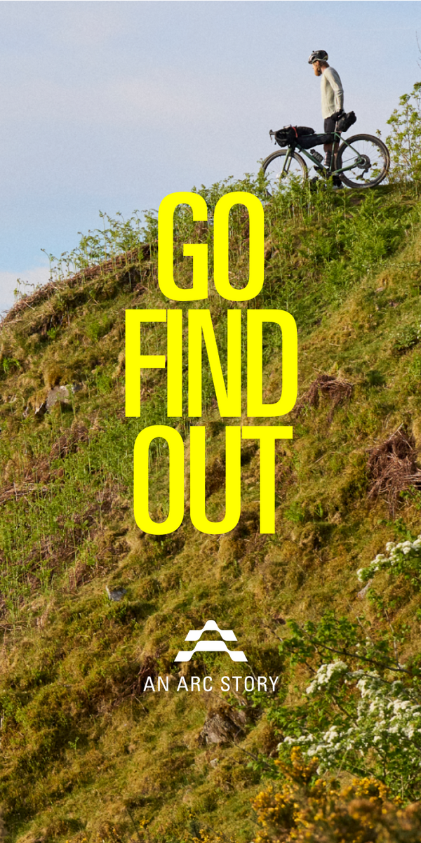 Grassy hillside with three gravel riders at the top, looking out.