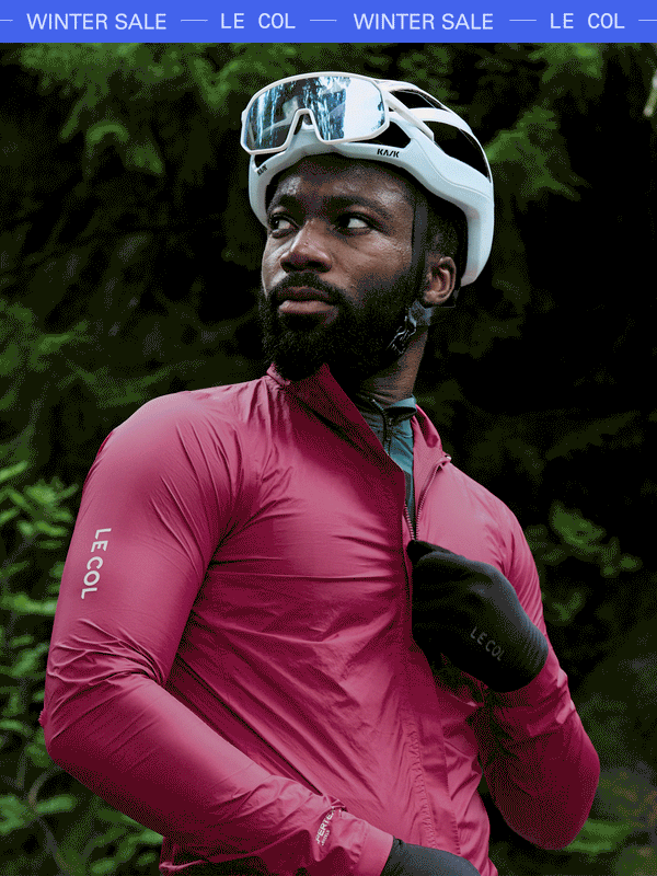 Male cyclist unzipping a pink jacket