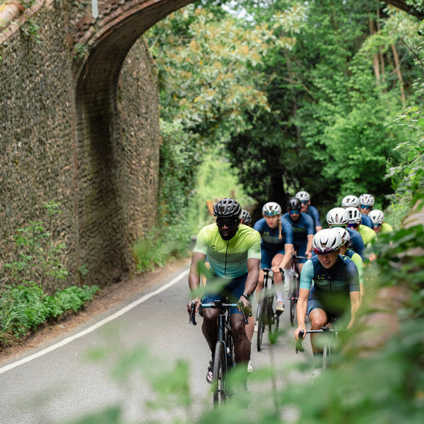 Group of cyclists riding towards on a wooded country road wearing LC_CC club kit