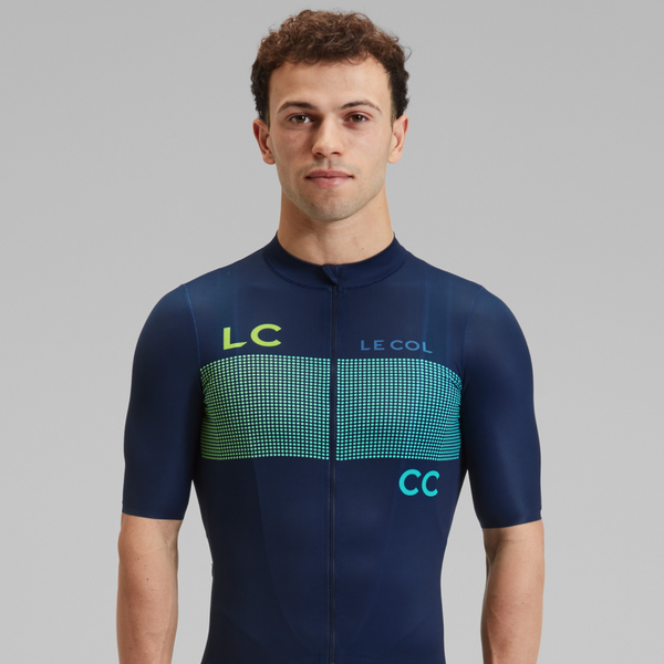 Studio shot of Male wearing short sleeved navy jersey with rows of dots across the chest