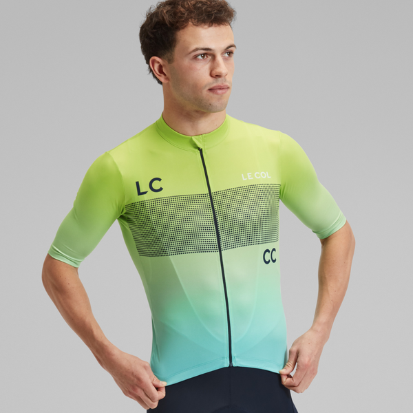 Studio shot of Male wearing short sleeved blue to green gradient jersey with rows of dots across the chest