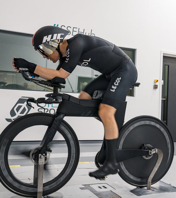 Cyclist in lent forward in race position on a static bike.