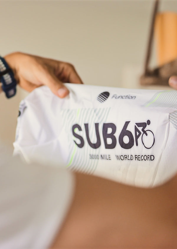 Hands holding up jersey with 'Sub6' printed in black.