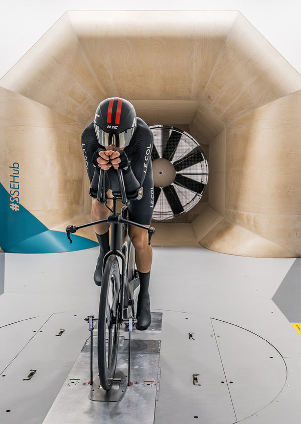 Cyclist leant forward in race position in the wind tunnel.