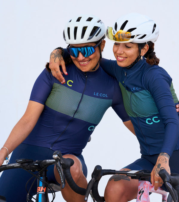 Two female cyclists with their arms around each other in Le Col LC__CC kit.