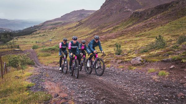 The Ribble team of four riding uphill with large rocky hills in the background. 