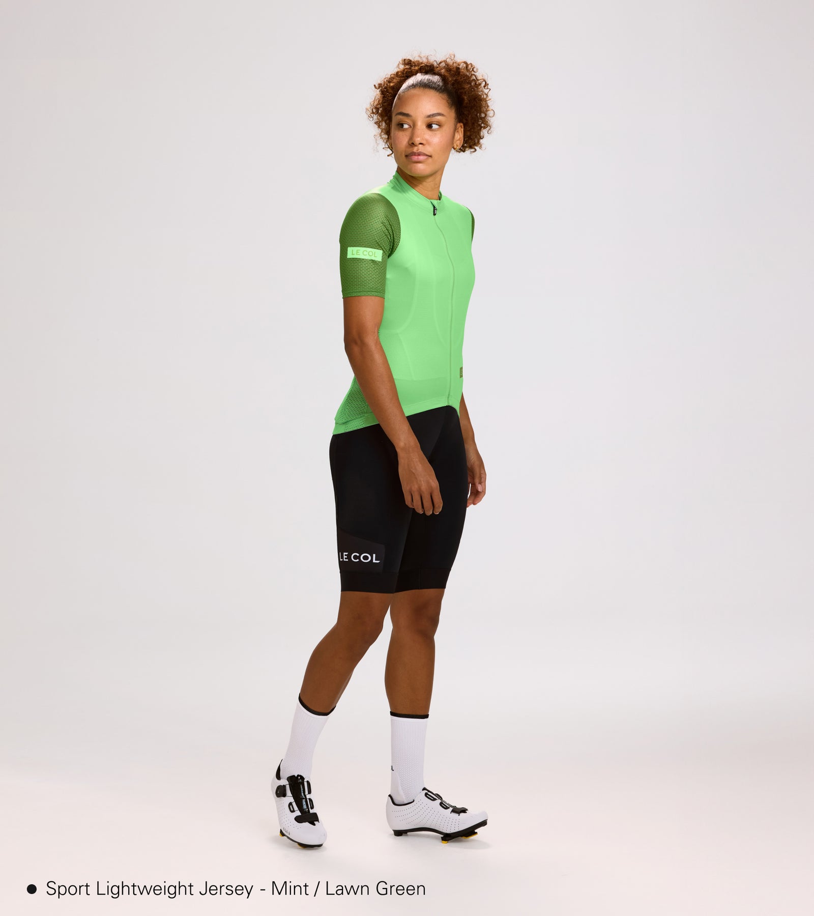 Studio shot of woman wearing mint green, lightweight jersey with green sleeves.