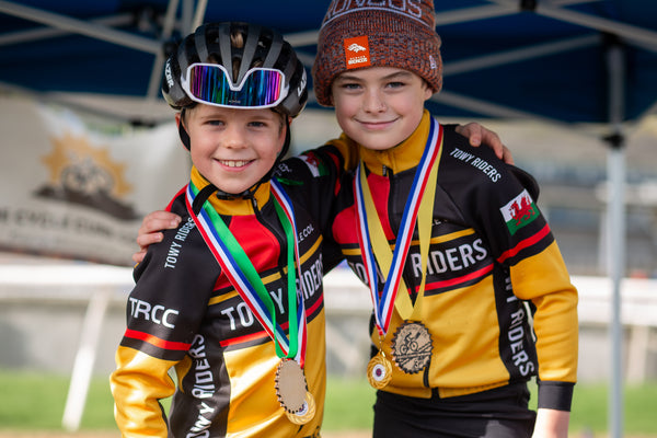 The smiling winners of the race with their medals around their necks in 'Towy Riders' Kit.